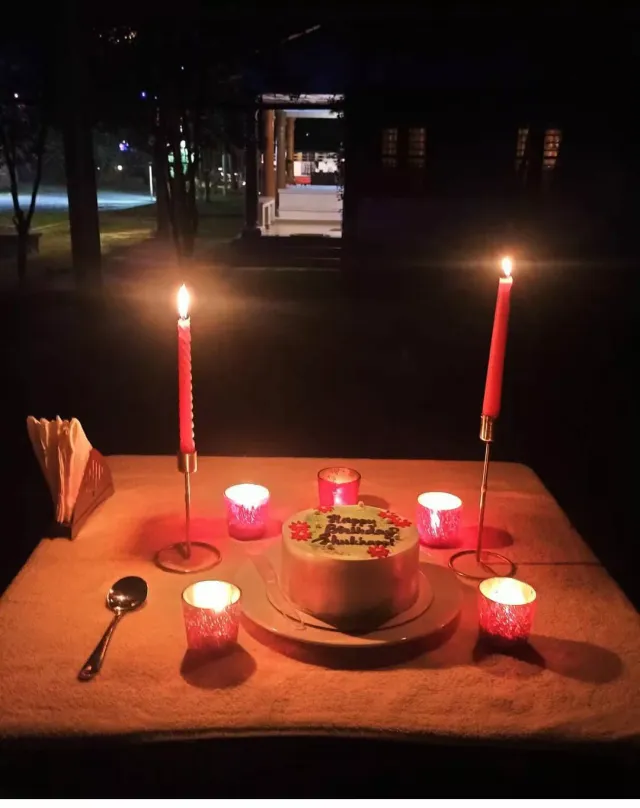 Candle-lit dinner table with birthday cake in the Casa Marari garden