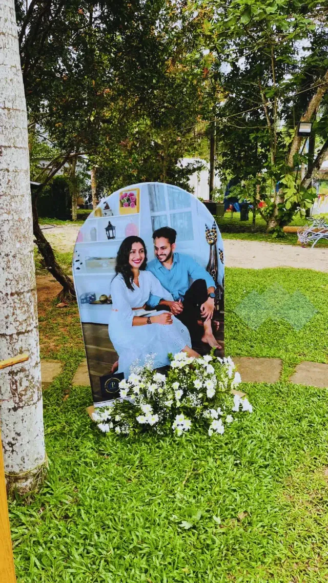 Couple photo standee decorated with flowers on the lawn