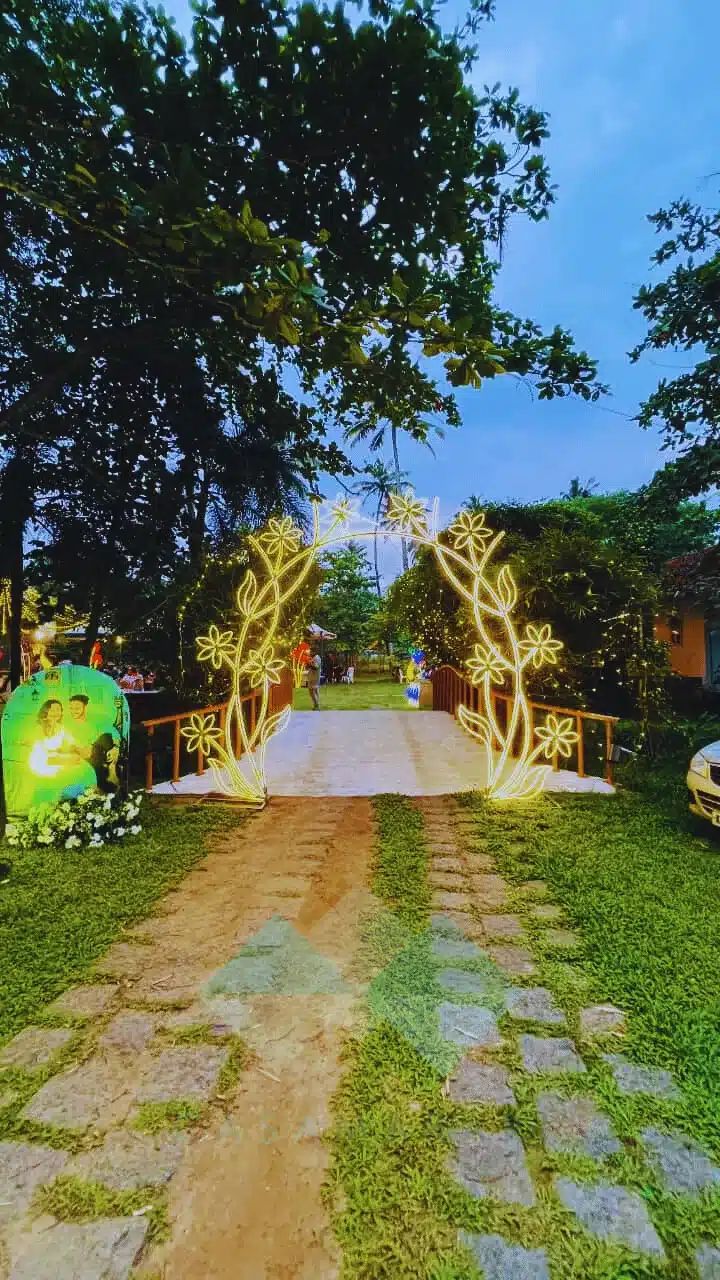 Illuminated floral arch over the walkway at an evening event at Casa Marari